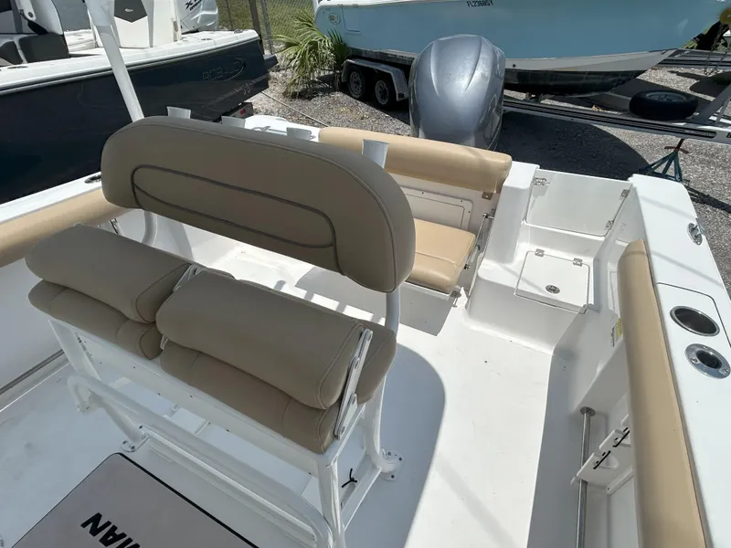 Slide: The Image of 2016 Sportsman Open 232 Center Console boat interior with beige seating and white deck. - 15