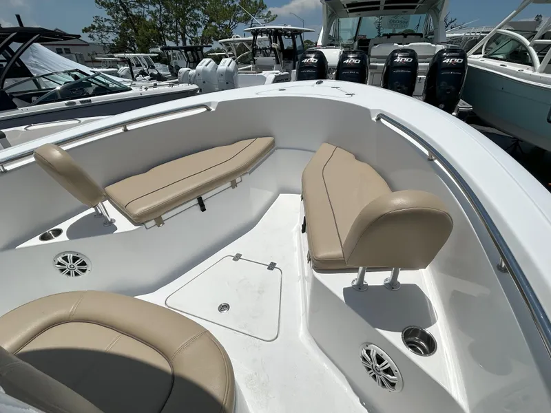 Slide: The Image of 2016 Sportsman Open 232 Center Console boat interior with beige seating and cup holders. - 16