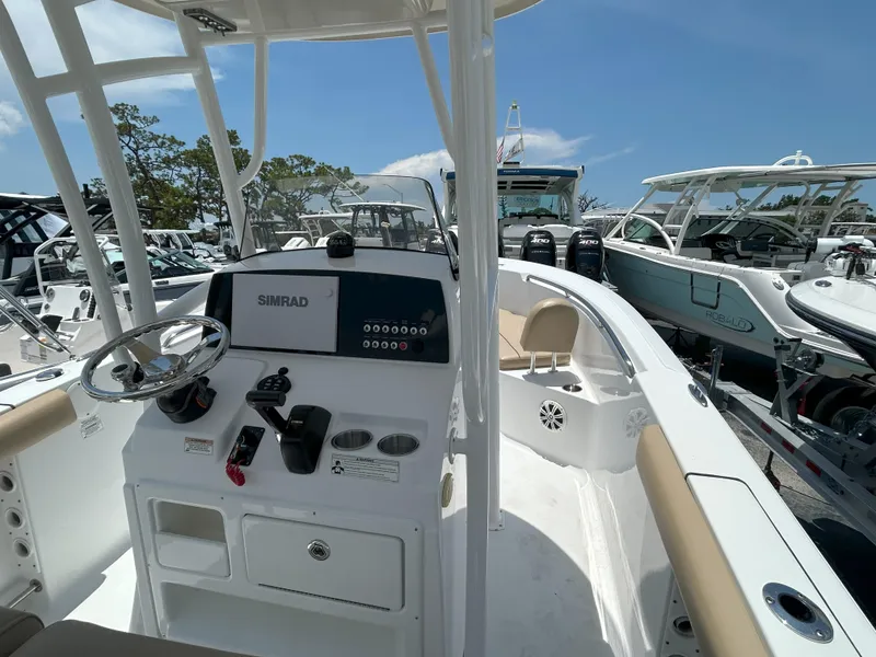 Slide: The Image of 2016 Sportsman Open 232 Center Console boat interior with steering wheel and Simrad display. - 7