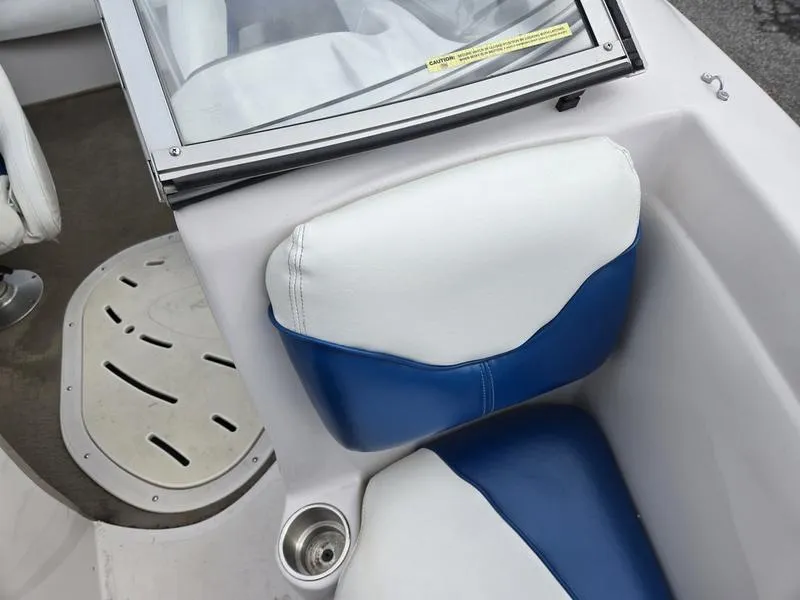 Slide: The Image of 2006 Tahoe Q6 boat interior with blue and white seating and cup holder. - 13