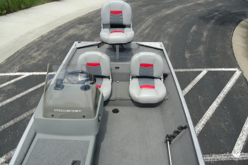 Slide: The Image of 2017 Tracker PRO160 boat with gray and red seating, parked on asphalt. - 4
