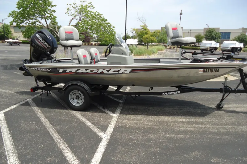 Slide: The Image of 2017 Tracker PRO160 boat on trailer in parking lot, featuring Mercury outboard motor. - 5