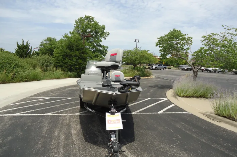 Slide: The Image of 2017 Tracker PRO160 boat parked in a lot, surrounded by greenery and trees. - 6