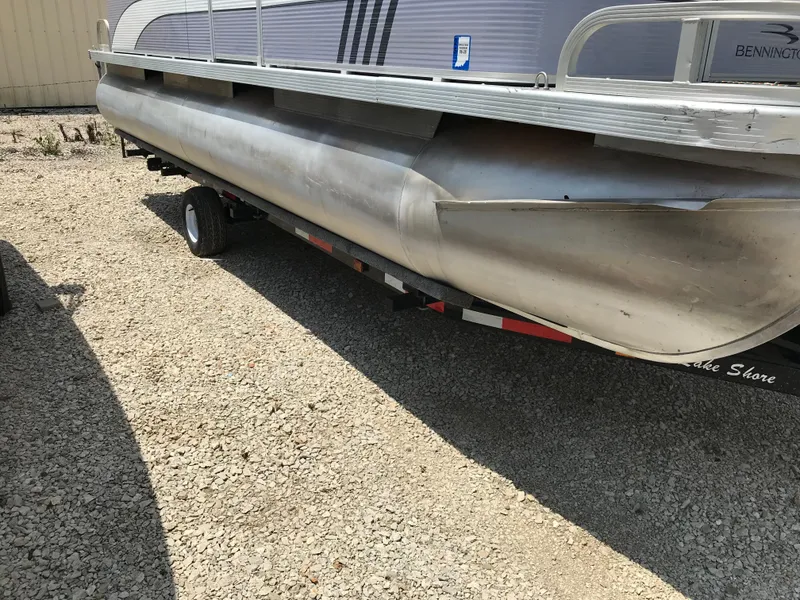 Slide: The Image of 1998 Bennington 2050LX pontoon boat on trailer, parked on gravel surface. - 17