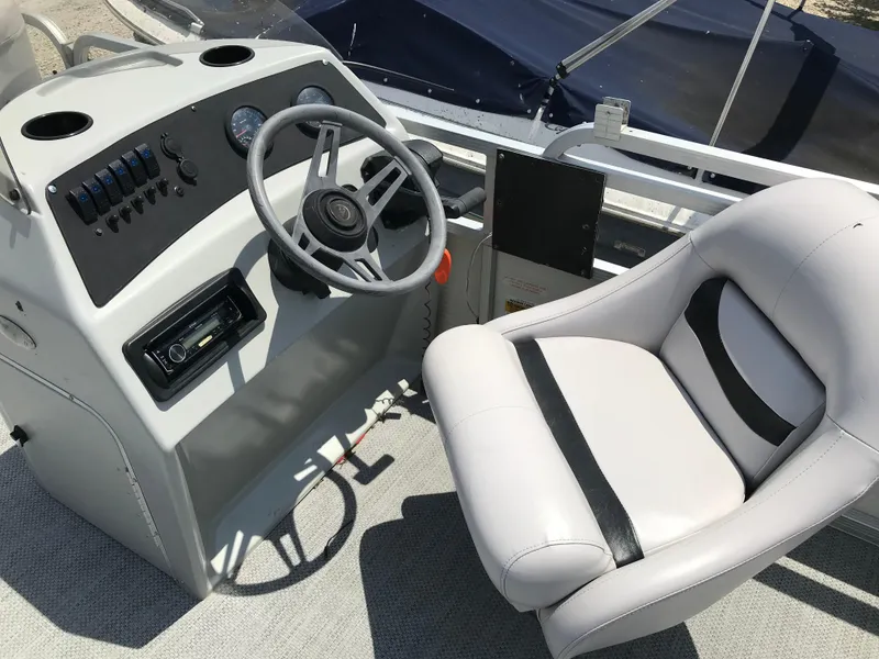 Slide: The Image of Captain's seat and helm of a 1998 Bennington 2050LX boat, featuring steering wheel and controls. - 9