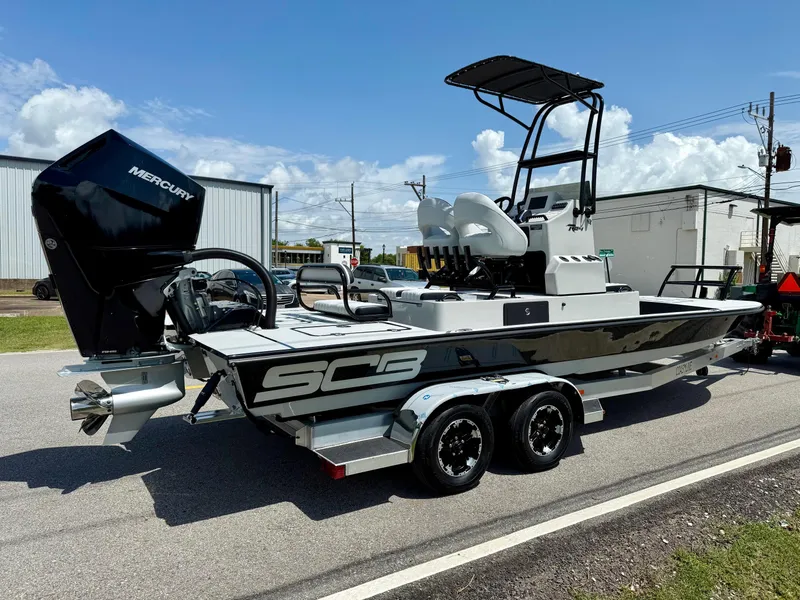 Slide: The Image of 2025 SCB R24 boat with Mercury engine on a trailer, parked outdoors. - 4