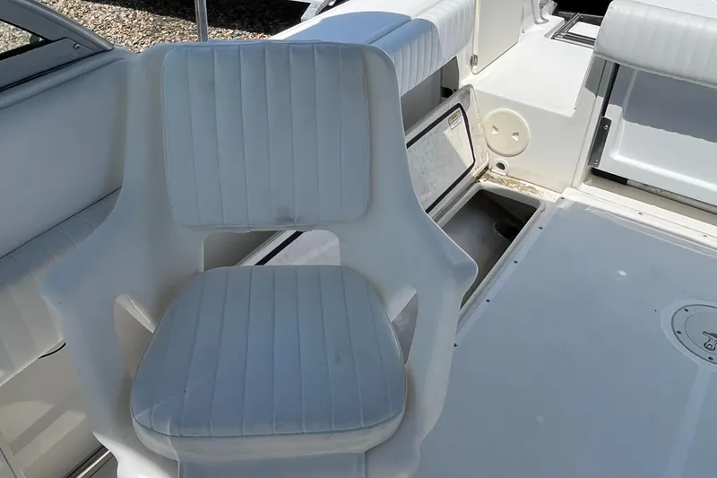 Slide: The Image of 2005 Boston Whaler 210 Ventura boat interior with white seating and storage compartments. - 10