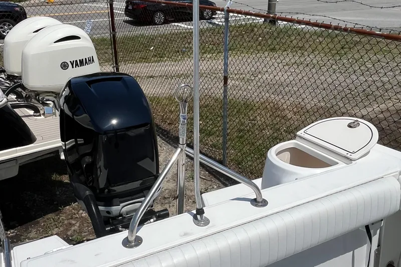 Slide: The Image of 2005 Boston Whaler 210 Ventura with Yamaha outboard motors, docked near a chain-link fence. - 11