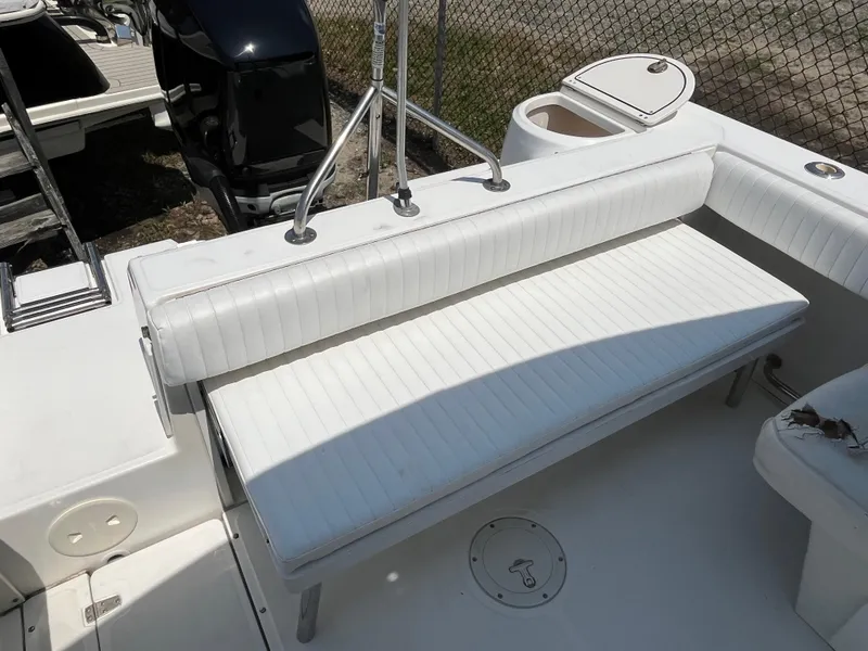 Slide: The Image of 2005 Boston Whaler 210 Ventura boat interior with white seating and storage compartment. - 14