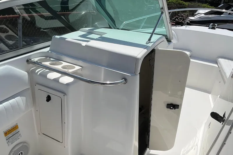 Slide: The Image of 2005 Boston Whaler 210 Ventura interior with open storage compartment and cup holders. - 19