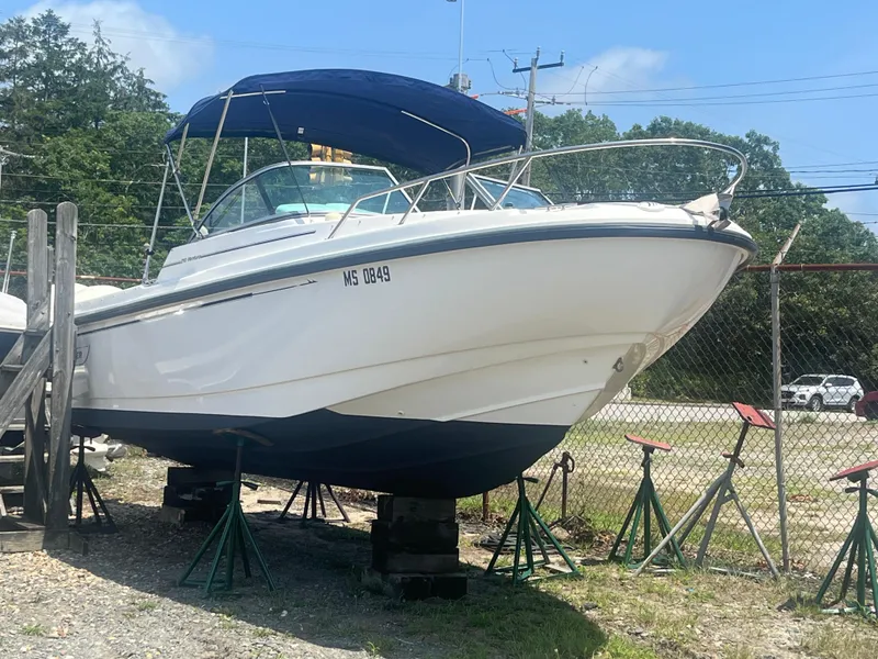Slide: The Image of 2005 Boston Whaler 210 Ventura boat on stands, blue canopy, outdoors. - 2