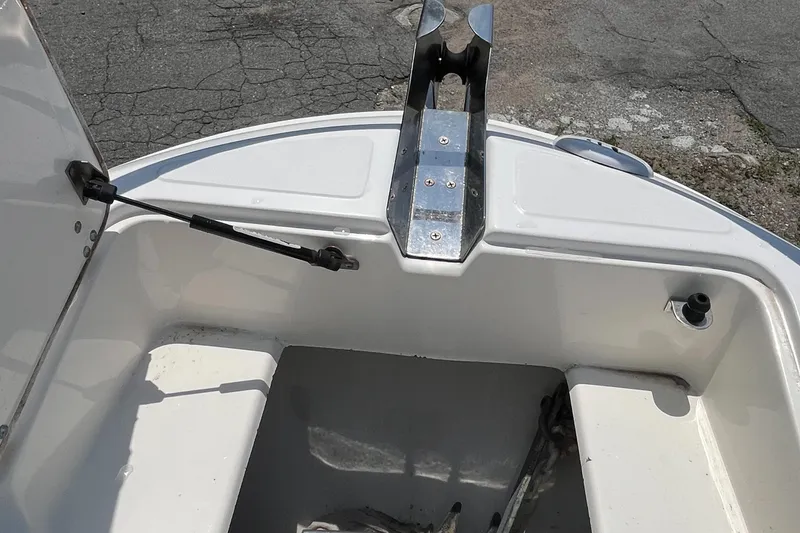 Slide: The Image of 2005 Boston Whaler 210 Ventura bow storage compartment with open hatch and metal fittings. - 24
