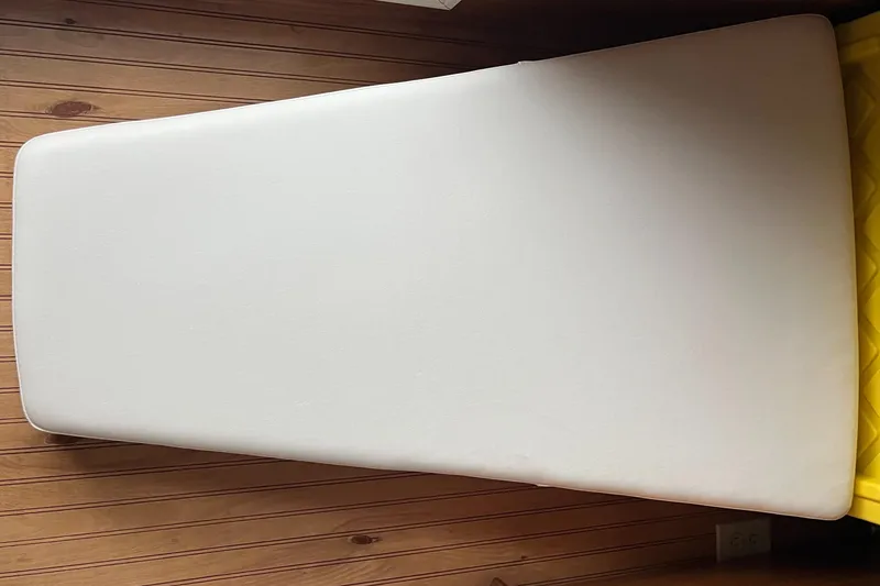 Slide: The Image of White cushion on wooden floor, possibly for a 2005 Boston Whaler 210 Ventura boat. - 26