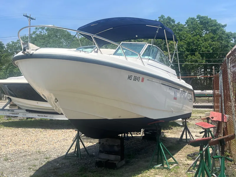 Slide: The Image of 2005 Boston Whaler 210 Ventura boat on stands, outdoors, with blue canopy. - 3