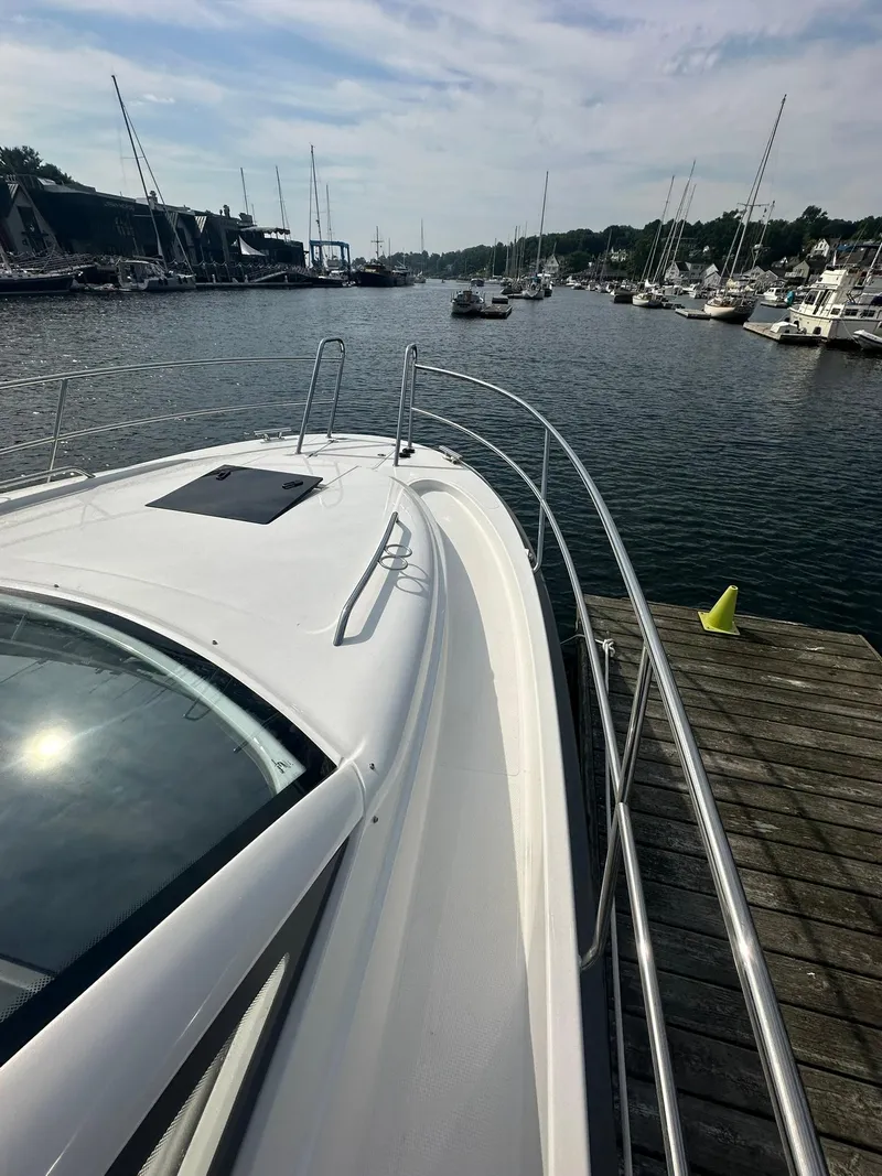 Slide: The Image of 2024 Nimbus 305 Coupe docked at a marina, surrounded by sailboats. - 28