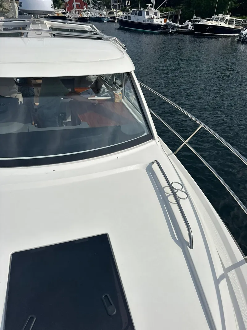 Slide: The Image of 2024 Nimbus 305 Coupe yacht docked in a marina, showcasing sleek design and spacious deck. - 45