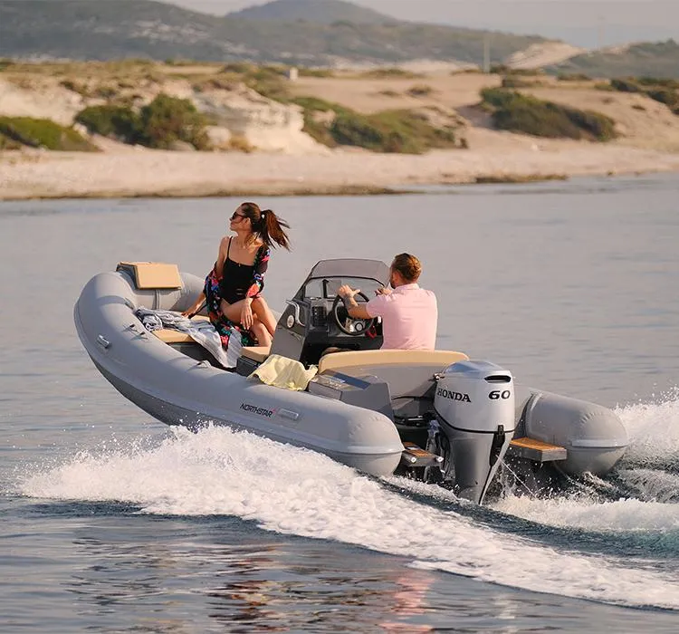Slide: The Image of 2021 Northstar Axis 4.8 boat cruising with two people, scenic coastal background. - 11