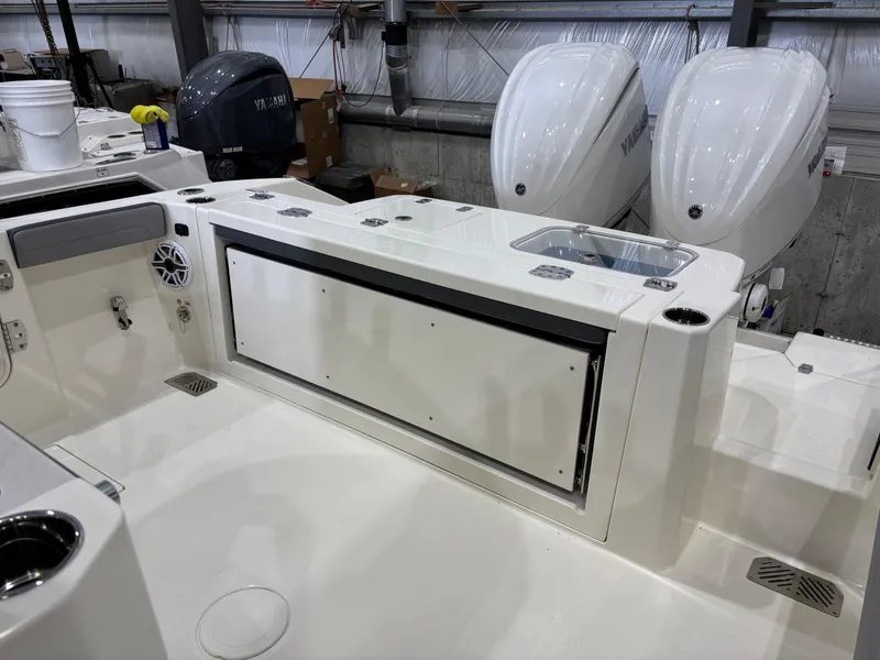 Slide: The Image of 2025 Cobia 285 Center Console boat interior with dual Yamaha engines in a garage setting. - 11