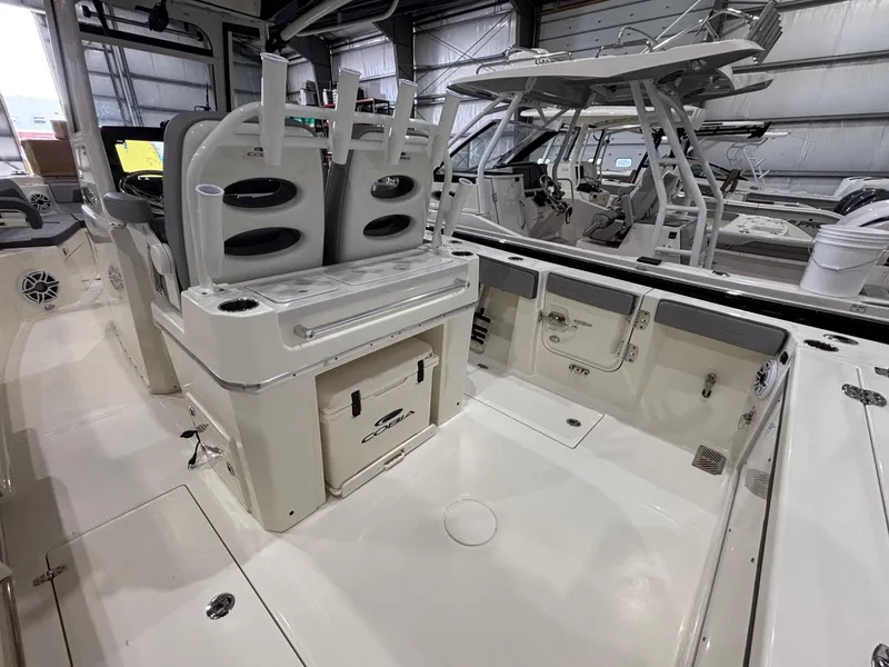 Slide: The Image of 2025 Cobia 285 Center Console boat interior with seating and storage in a showroom. - 17