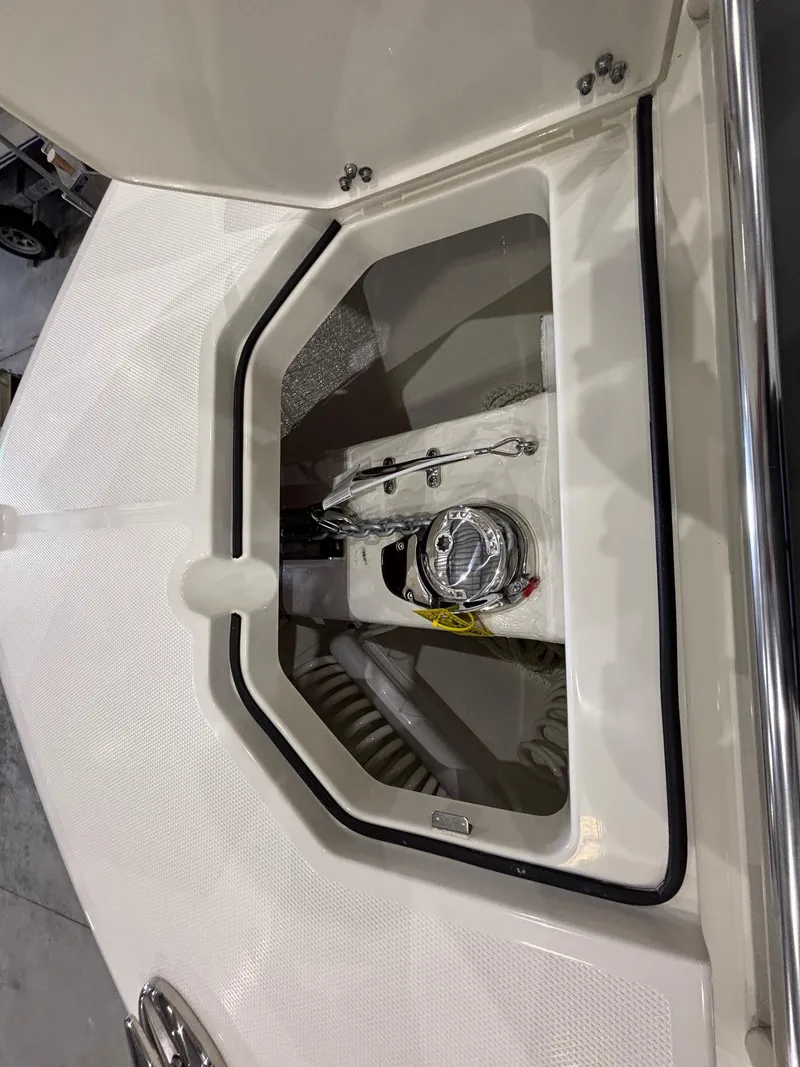 Slide: The Image of 2025 Cobia 285 Center Console boat compartment with open hatch, showcasing interior details. - 22