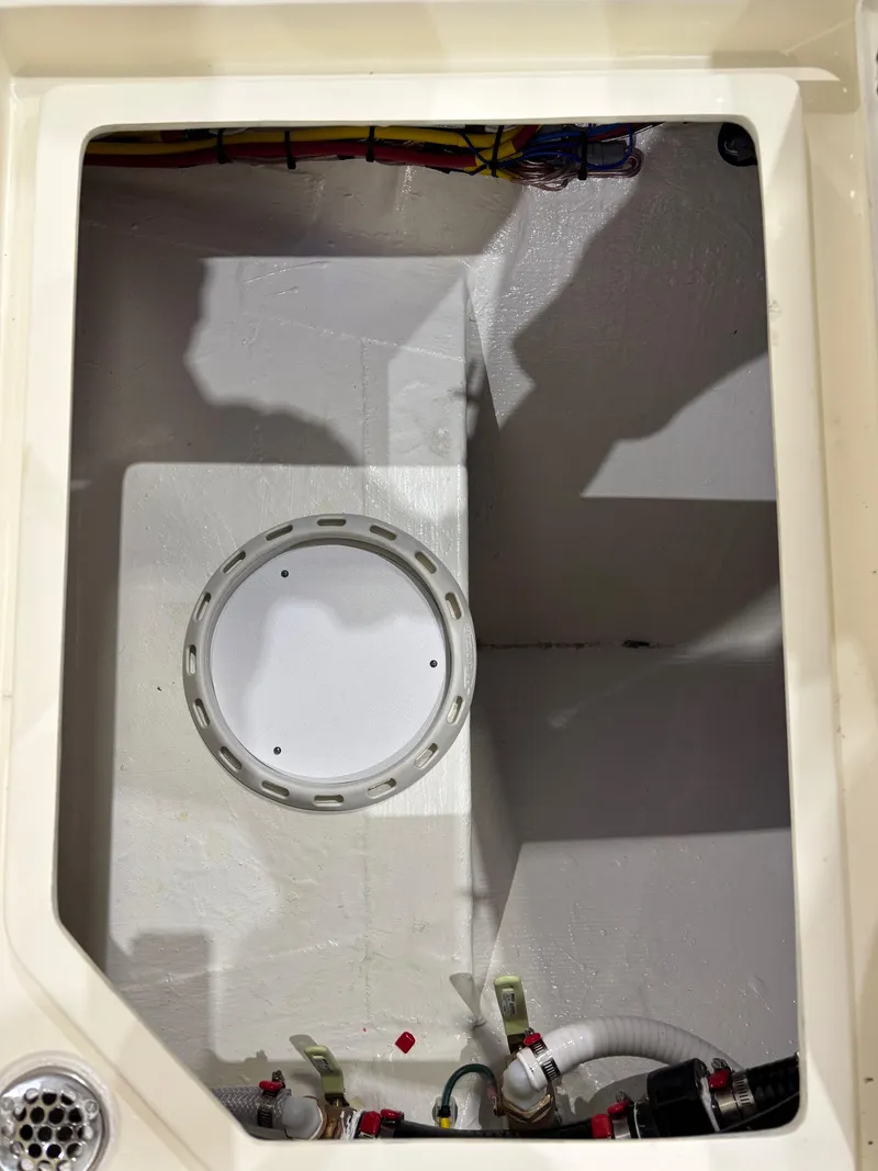 Slide: The Image of 2025 Cobia 285 Center Console boat compartment with wiring and plumbing details. - 24