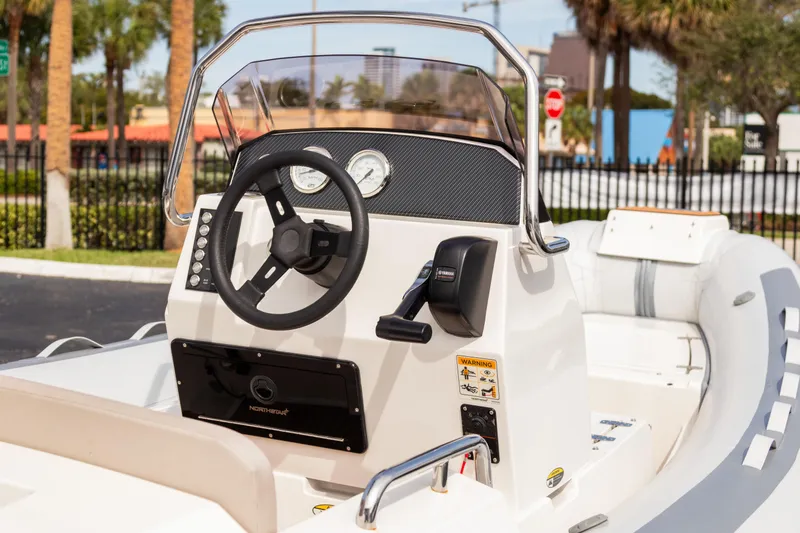 Slide: The Image of 2023 Northstar Axis 4.8 RIB boat dashboard with steering wheel and controls. - 3