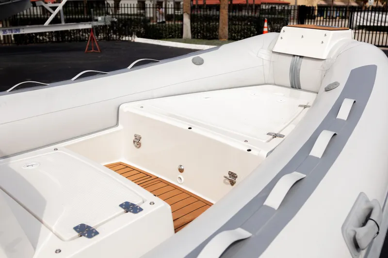 Slide: The Image of 2023 Northstar Axis 4.8 RIB boat interior with white seating and wood accents. - 4