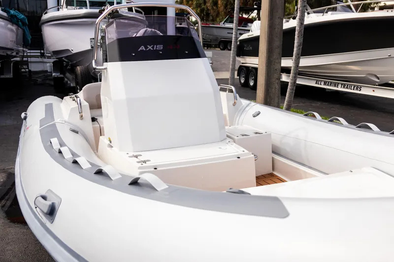 Slide: The Image of 2023 Northstar Axis 4.8 RIB boat, sleek design, docked in a marina. - 5