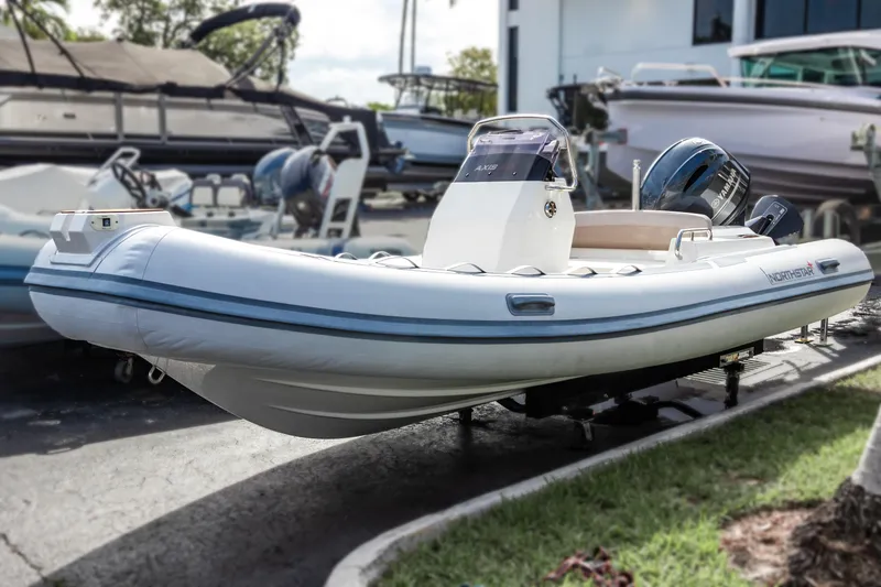 Slide: The Image of 2023 Northstar Axis 4.8 RIB boat displayed outdoors, featuring sleek design and modern outboard motor. - 7
