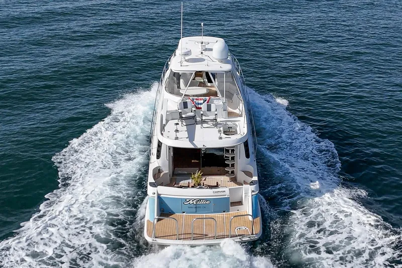 Slide: The Image of 2003 Carver 570 Voyager Pilothouse yacht cruising on open water. - 18