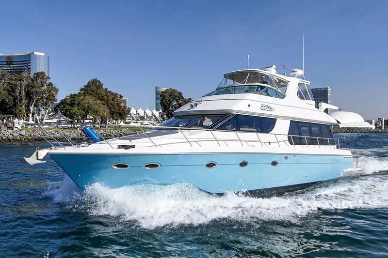 Slide: The Image of 2003 Carver 570 Voyager Pilothouse yacht cruising on a sunny day near urban waterfront. - 4