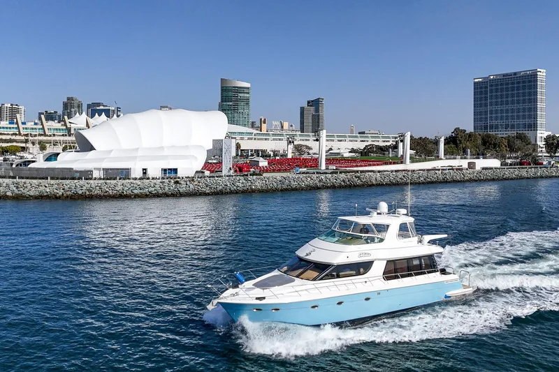 Slide: The Image of 2003 Carver 570 Voyager Pilothouse yacht cruising near modern waterfront buildings. - 8