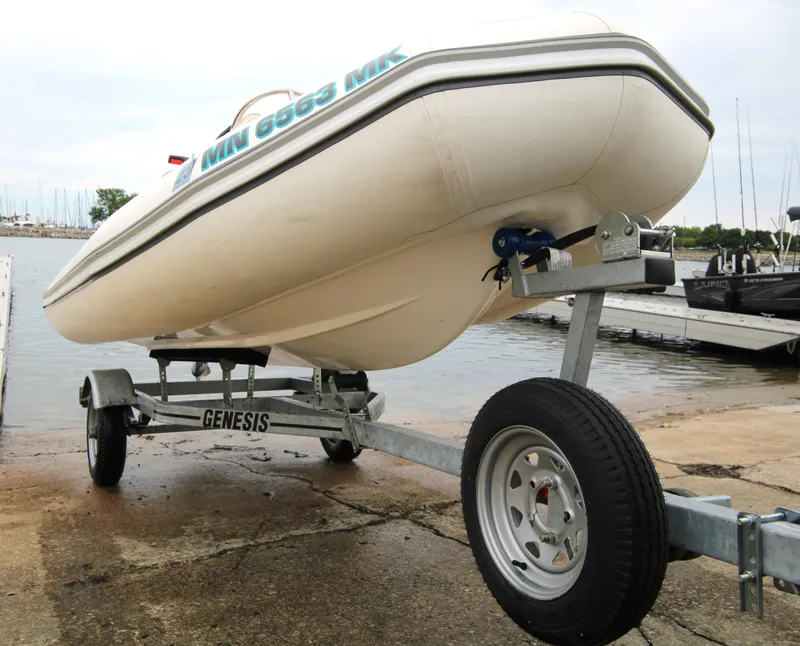 Slide: The Image of 2022 Zodiac Yachtline 360DL NEO on Genesis trailer by a lakeside dock. - 6