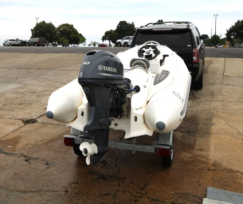 Slide: The Image of 2022 Zodiac Yachtline 360DL NEO with Yamaha engine on trailer, parked near SUV. - 8