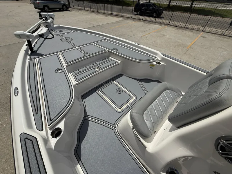 Slide: The Image of 2022 Blue Wave 2400 PureBay boat with spacious deck and seating, parked outdoors. - 10