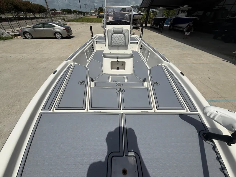 Slide: The Image of 2022 Blue Wave 2400 PureBay boat interior with gray seating and modern controls. - 11