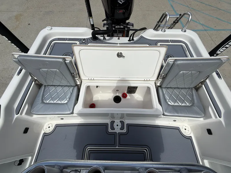 Slide: The Image of 2022 Blue Wave 2400 PureBay boat deck with open storage compartments and motor. - 14