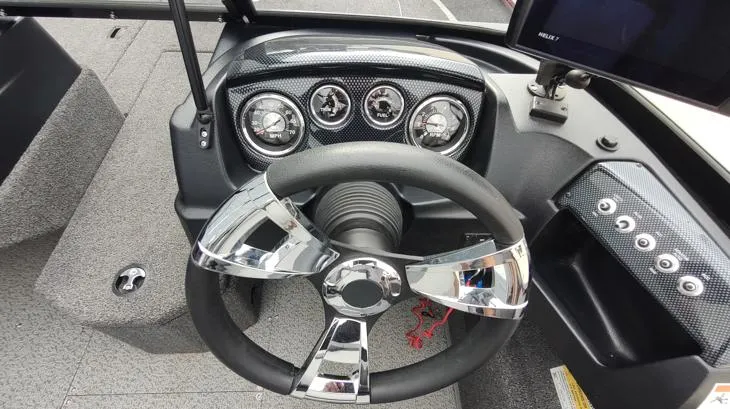 Slide: The Image of 2023 Lowe FM 1775 boat dashboard with chrome steering wheel and instrument panel. - 15