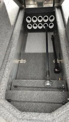 Slide: The Image of 2023 Lowe FM 1775 boat storage compartment with rod holders and carpeted interior. - 23
