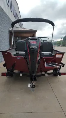 Slide: The Image of 2023 Lowe FM 1775 boat, rear view, parked on concrete, overcast sky. - 26