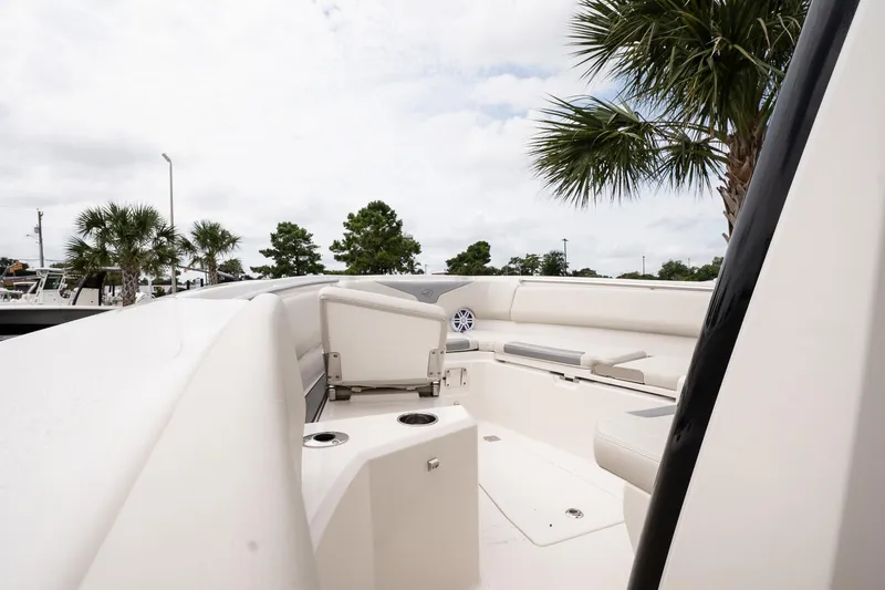 Slide: The Image of 2026 Sailfish 232 CC boat interior with seating, cup holders, and palm trees in the background. - 16