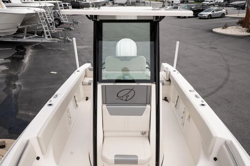 Slide: The Image of 2026 Sailfish 232 CC boat interior with seating and console, parked in a marina. - 18