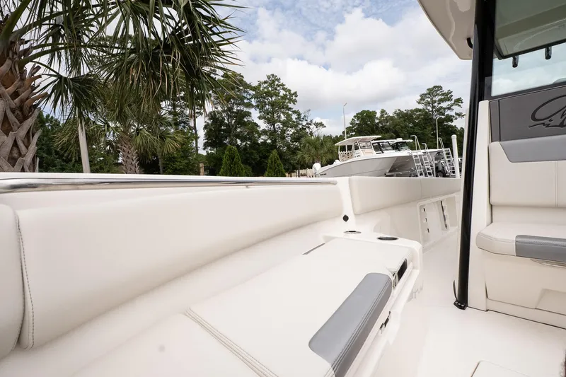 Slide: The Image of 2026 Sailfish 232 CC boat interior with white seating, palm trees, and blue sky background. - 19