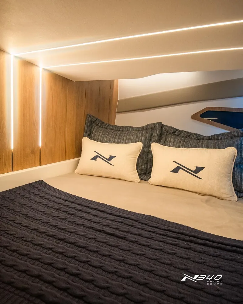 Slide: The Image of Luxurious cabin interior of 2025 NX Boats NX340 Sport with elegant bedding and ambient lighting. - 4