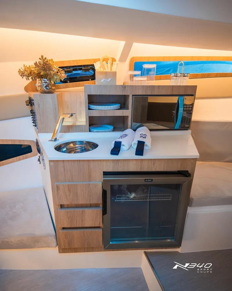 Slide: The Image of Modern kitchenette in 2025 NX Boats NX340 Sport, featuring sink, microwave, and mini-fridge. - 5