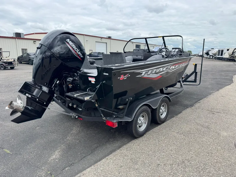 Slide: The Image of 2023 Tracker Targa V-18 WT boat with Mercury engine on a trailer, parked outdoors. - 3