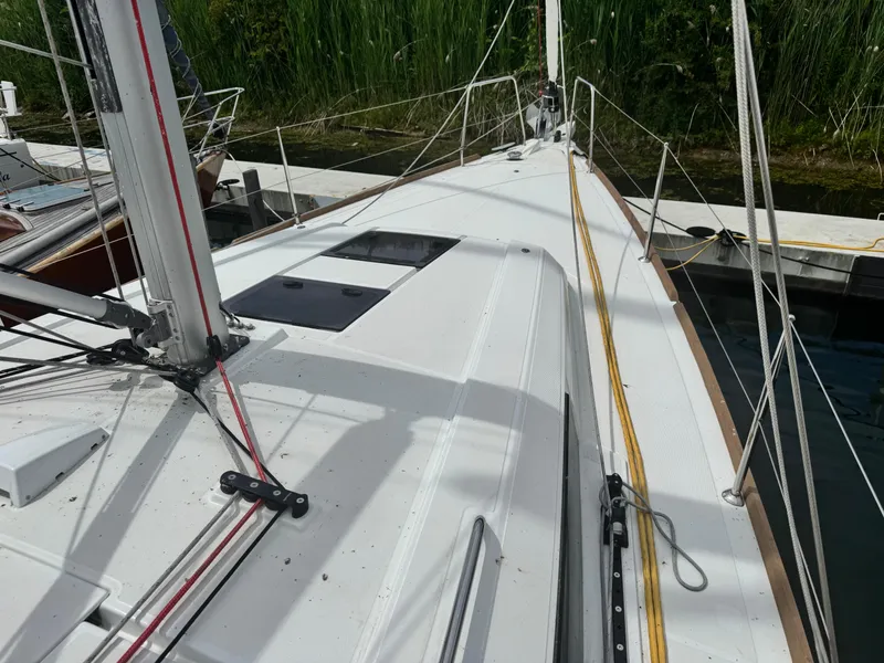 Slide: The Image of 2023 Beneteau Oceanis 38.1 sailboat docked, showcasing deck and dual steering wheels. - 13