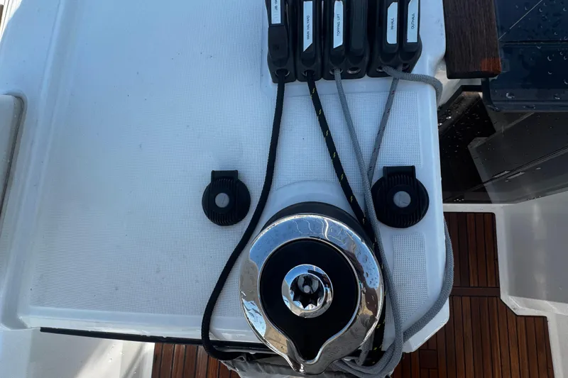 Slide: The Image of 2023 Beneteau Oceanis 38.1 sailboat deck with urban industrial backdrop. - 38