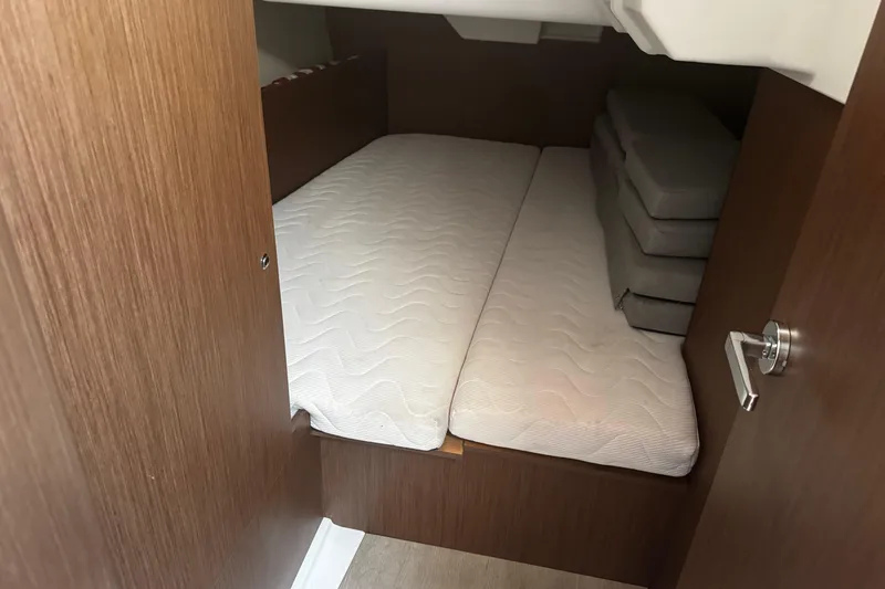 Slide: The Image of 2023 Beneteau Oceanis 38.1 cabin with cozy bed and patterned pillows. - 47