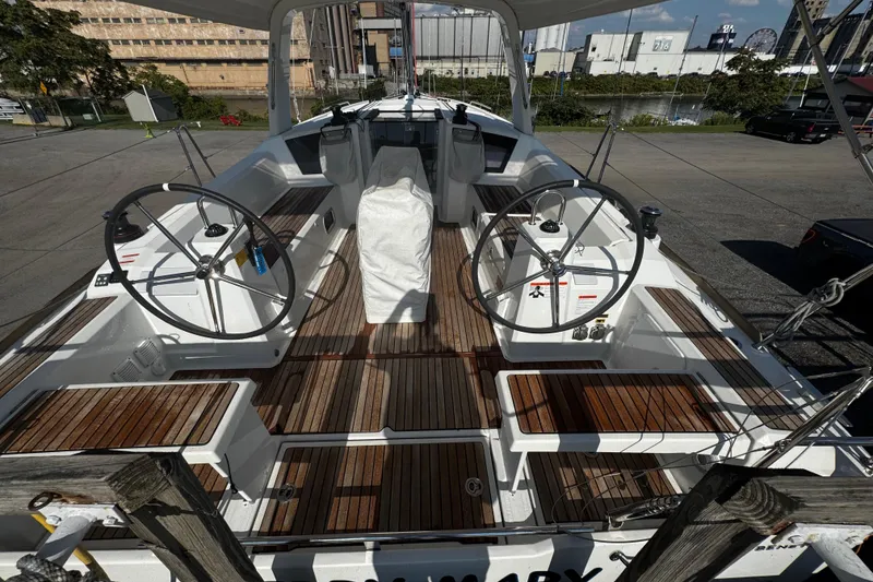 Slide: The Image of 2023 Beneteau Oceanis 38.1 sailboat cockpit with dual steering wheels and teak decking. - 52